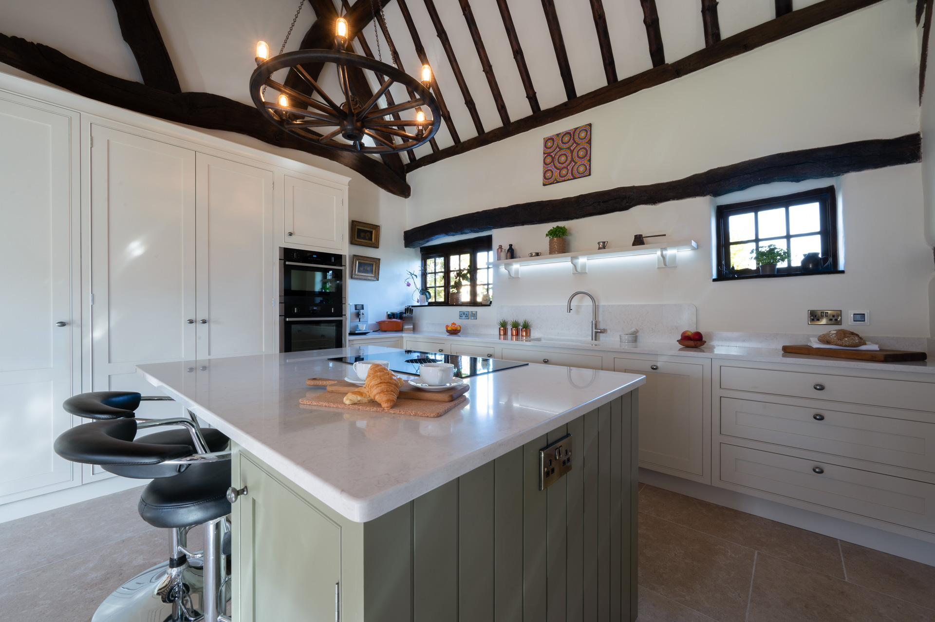 Green shaker kitchen with island seating and wood flooring