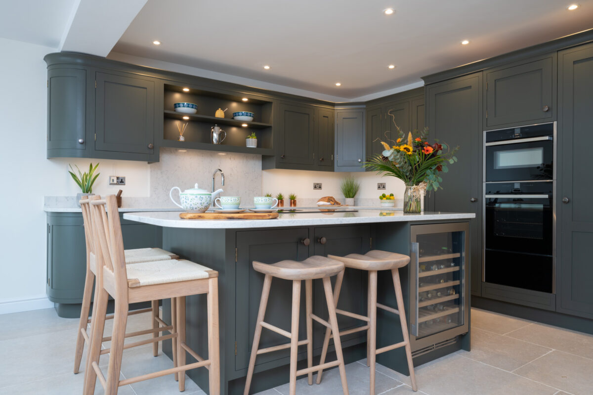Contemporary handmade shaker kitchen by Holme Tree with dark painted cabinetry, central island seating, integrated wine cooler, and bespoke storage solutions.